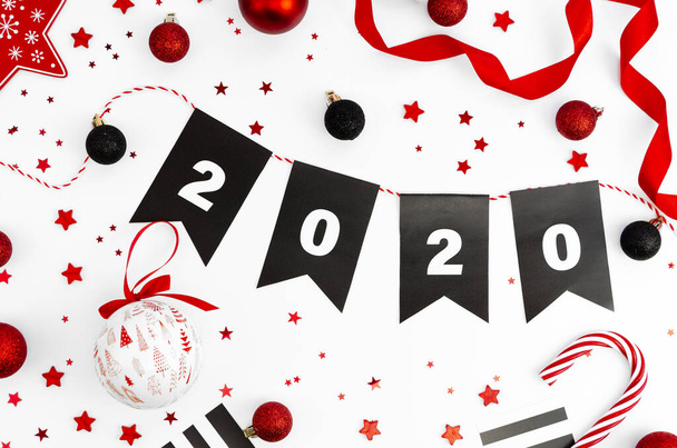 Vlakke lay Kerst of Nieuwjaar achtergrond met nummer 2020, rood en wit kerstversiering op witte achtergrond - Foto, afbeelding