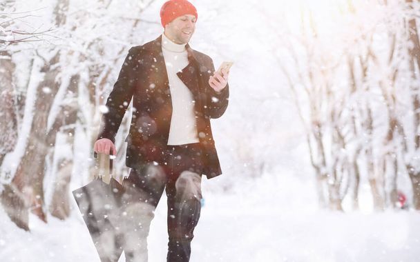 Человек на прогулке в парке. Молодой человек с зимним снегом
 - Фото, изображение