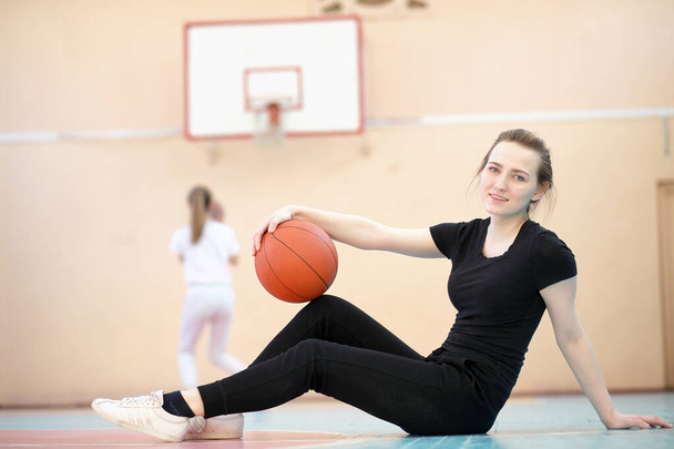 Girl in the gym playing a basketball - Фото, изображение
