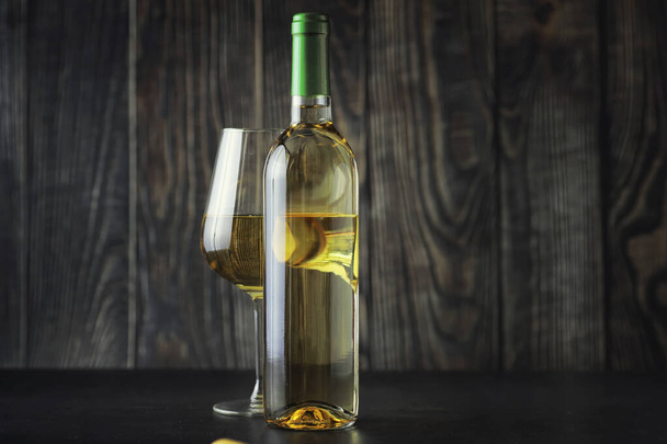 Transparent bottle of white dry wine on the table. White wine gl - Foto, Bild