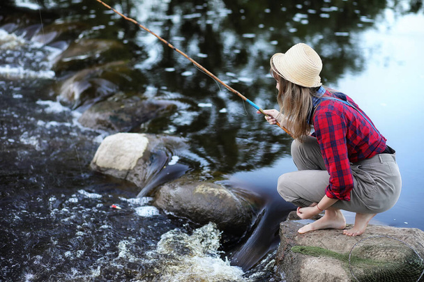 Menina junto ao rio com uma vara de pesca
 - Foto, Imagem