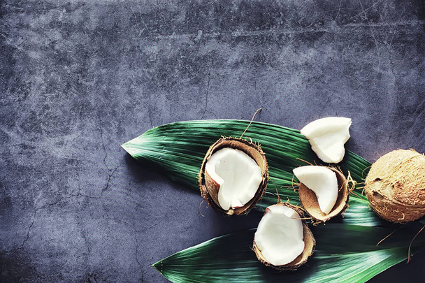 Kokosnuss auf einem dunklen Steintisch. Kokosöl. - Foto, Bild