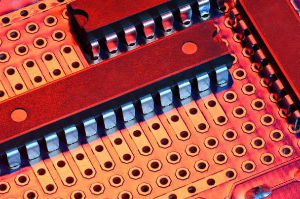 painettu piirilevy ja mikrosiru punaisessa valossa lähikuva - digitaalisten laitteiden elektroninen komponentti, konsepti sähköisten tietokonepiirien kehittämiseksi
 - Valokuva, kuva