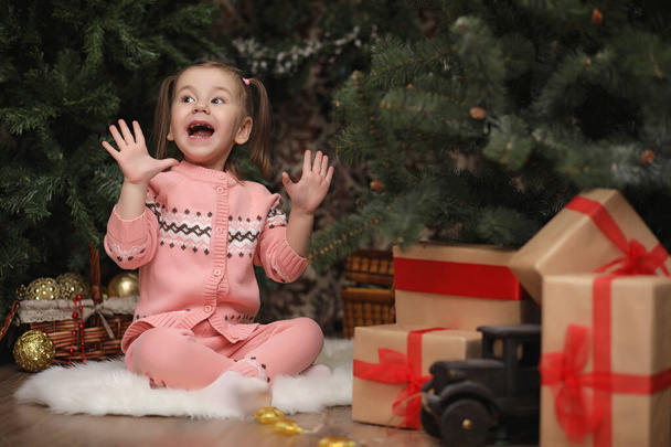 Little girl in new year's Christmas atmosphere. The girl is happ - Foto, Imagen