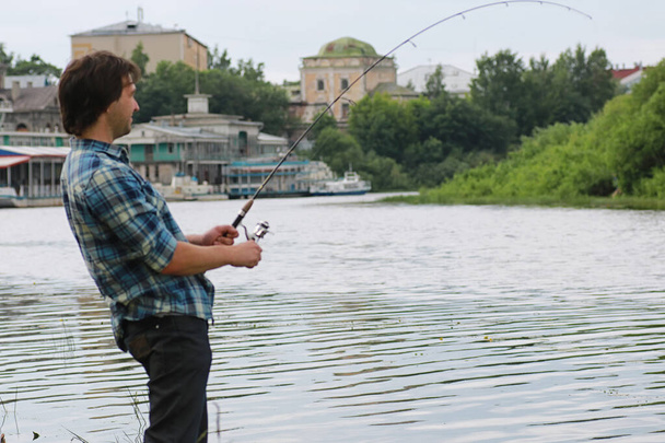 Человек с бородой рыбачит в реке
 - Фото, изображение