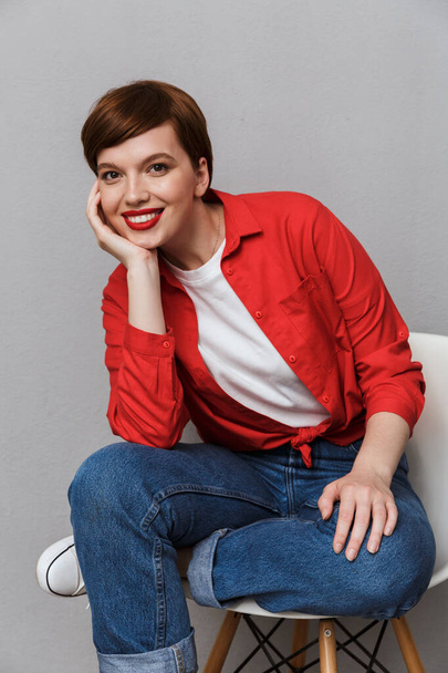 Image of gorgeous young woman smiling while sitting on chair - Fotografie, Obrázek