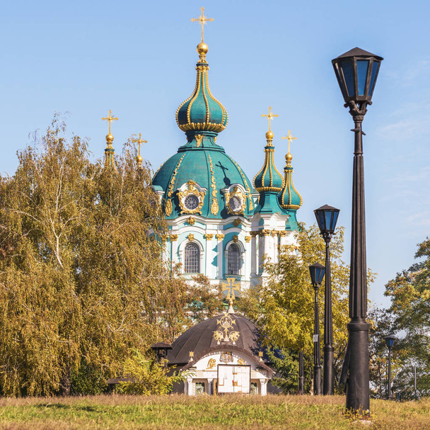 Vue de l'église Saint-André à travers les arbres dans un parc d'automne à Kiev, en Ukraine
. - Photo, image