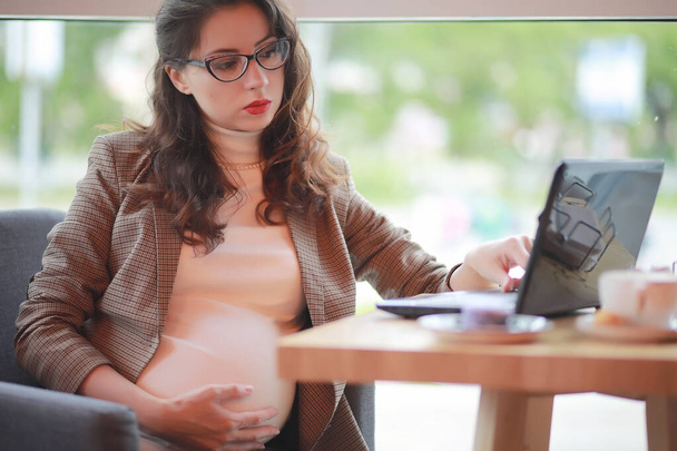 Femme enceinte travaillant sur ordinateur dans un café
 - Photo, image