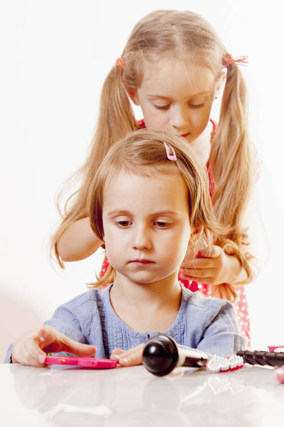 Little cute girl hairdresser makes hairstyle. Happy child client - 写真・画像