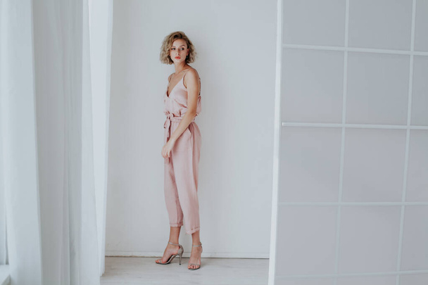 Retrato de moda de una hermosa mujer vestida de rosa en una habitación blanca
 - Foto, Imagen