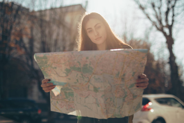 Woman tourist exploring city while holding map - Valokuva, kuva
