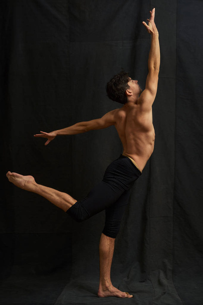 Young studio ballet dancer is dancing. A man is photographed from the back. - Foto, Imagen