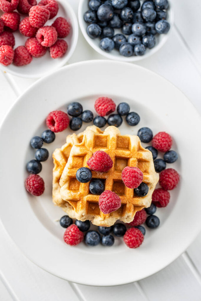 Waffles with blueberries and raspberries. - Zdjęcie, obraz