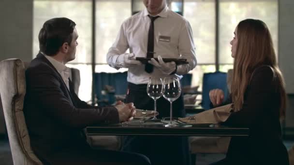Glückliches Paar beim Gespräch im Restaurant. Tisch. Geschäftspaar liest Menü im Café - Filmmaterial, Video
