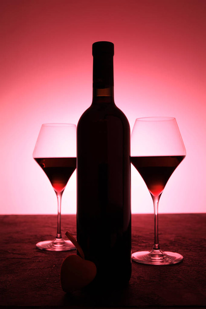 Love and romance, a bottle of red wine and a heart. - Photo, Image