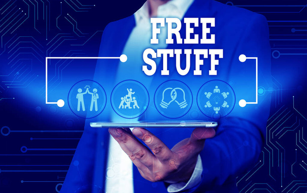 Conceptual hand writing showing Free Stuff. Business photo text Any thing that you can have in a store that is not being paid Male wear formal work suit presenting presentation smart device. - Photo, Image