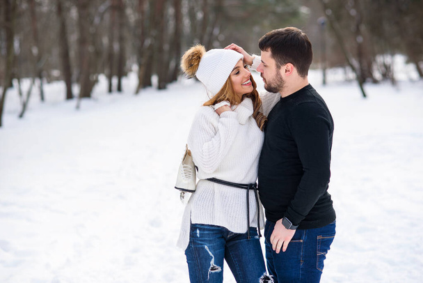 Beautiful couple in love hugging each other while walking in a winter Park. - 写真・画像