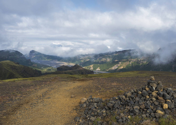 Tájkép Godland és tövis kő halom, masszív zöld moha borított sziklák és dombok, hajlító folyó kanyon, Izland, Fimmvorduhals túraútvonal. Nyári felhős nap. - Fotó, kép