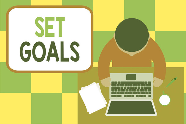 Conceptual hand writing showing Set Goals. Business photo showcasing Defining or achieving something in the future based on plan Upper view young man sitting table laptop coffee cup pen. - Photo, Image