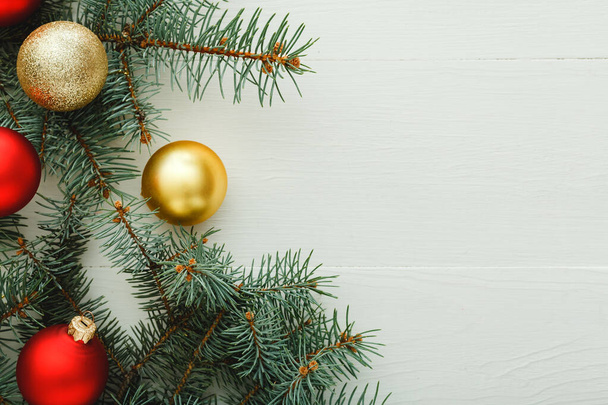Kerstmis Nieuwjaar 2020 feestdag patroon compositie gemaakt van rode ballen, sparren takken op witte houten achtergrond. Concept Kerst, winter. Vlakke lay, bovenaanzicht, kopieerruimte - Foto, afbeelding