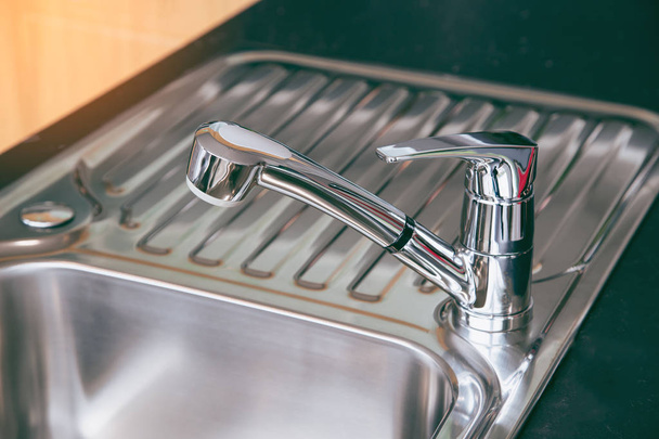 Kitchen faucet polished chrome and sink polished chrome.  - Photo, Image