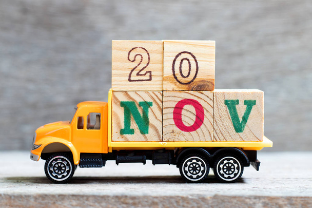 Вантажівка тримає блок літер у слові 20nov на фоні дерева ( Концепція на дату 20 місяців листопад
) - Фото, зображення