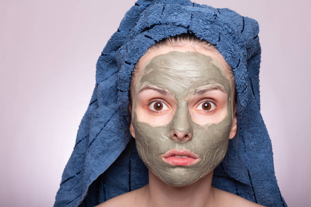young woman in a towel on her head and mask on her face - Foto, Imagen