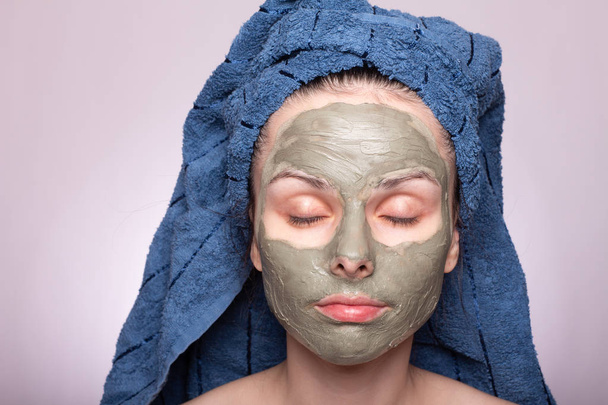 young woman in a towel on her head and mask on her face - Foto, Bild