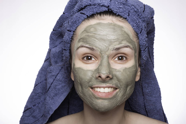 young woman in a towel on her head and mask on her face - Foto, imagen