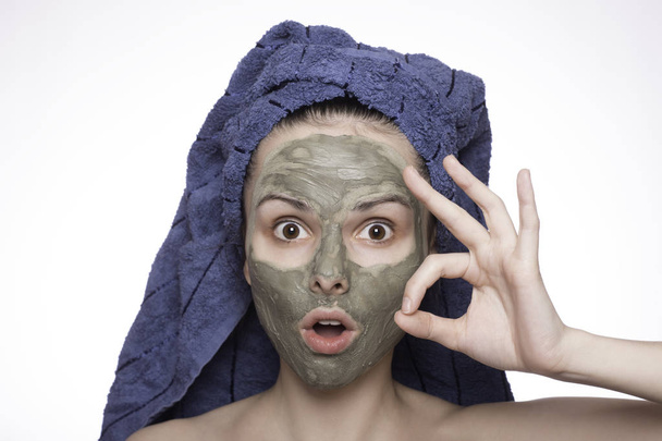 young woman in a towel on her head and mask on her face - Foto, afbeelding