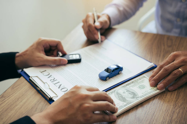New car buyers are signing a contract with a car salesman at the - Φωτογραφία, εικόνα