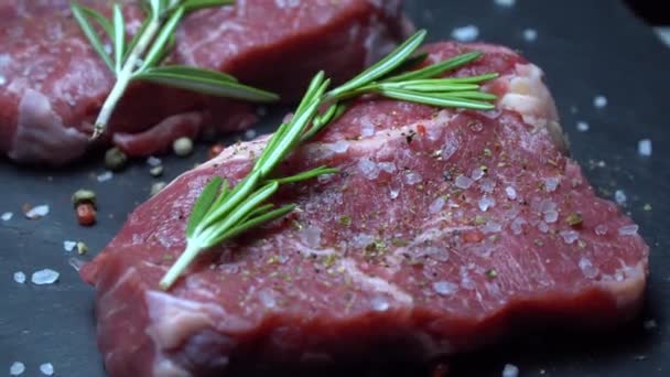 rohes Steak mit Gewürzen auf dunklem Hintergrund - Filmmaterial, Video
