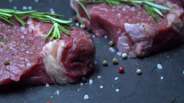 Syrový steak s kořením na tmavém pozadí - Záběry, video