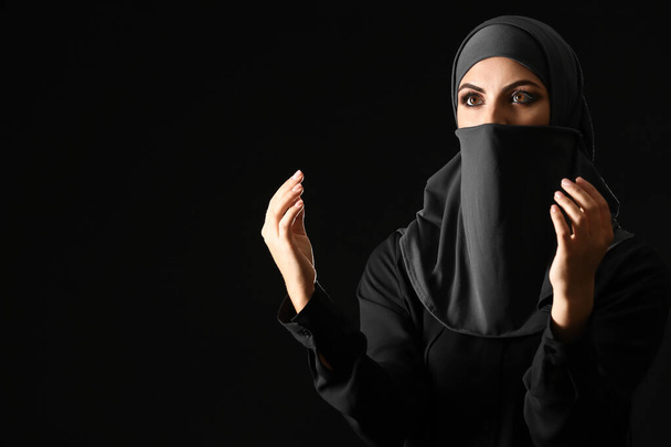 Bella donna musulmana che prega sullo sfondo scuro
 - Foto, immagini