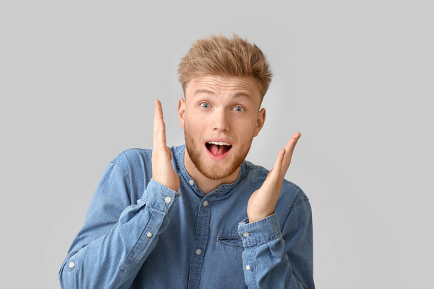 Surprised young man on light background - Photo, Image