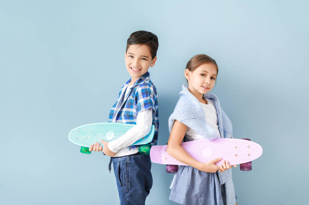 Cute fashionable children with skateboards near color wall - Foto, Imagen