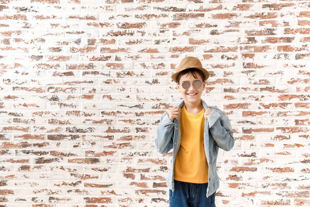 Aranyos divatos fiú ellen téglafal - Fotó, kép