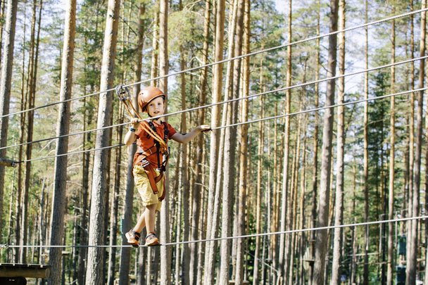 Pequeño niño escalando cuerda rastro
. - Foto, imagen