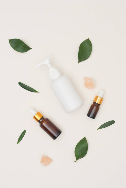 Serum or essential oil w/ organic herbal extract and skincare bottles on white background. Natural beauty cosmetic product. Top view - Photo, Image
