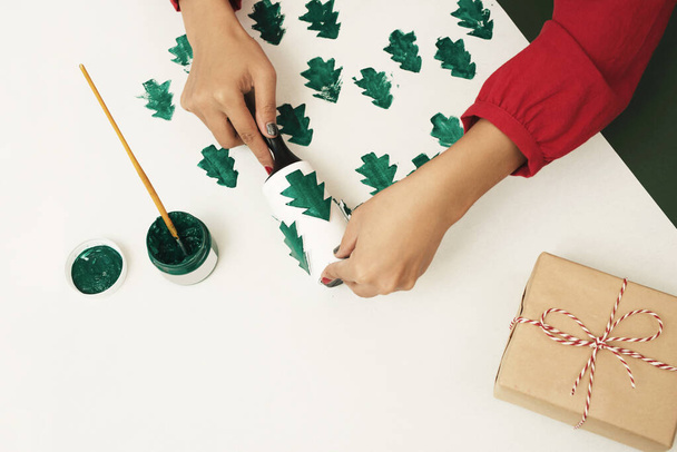 Женщина делает подарок на рождественскую бумагу. Noel, xmas concept
 - Фото, изображение