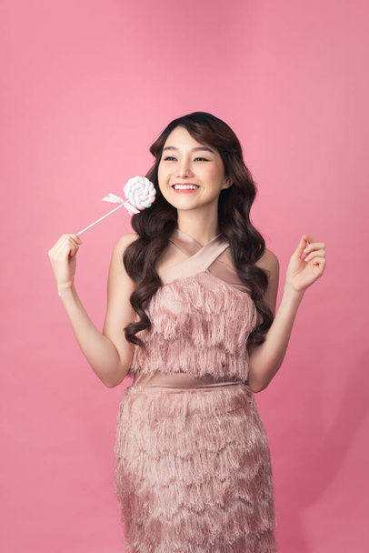 Fashion young woman with sweet makeup holding lolipop in her hands - Photo, image