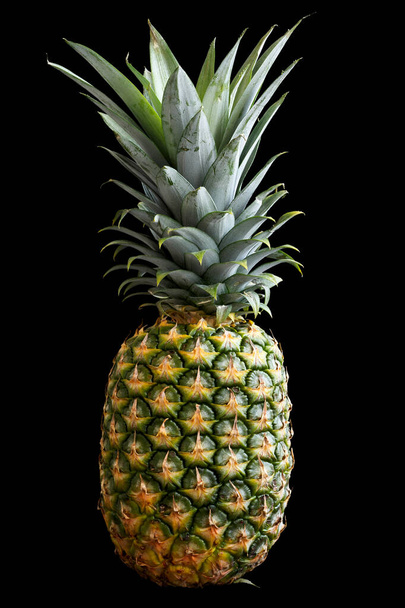 Whole pineapple isolated standing on black. - Foto, Imagen