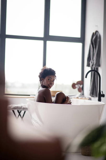 Dark-haired woman having bath in big bathroom - Foto, Imagen