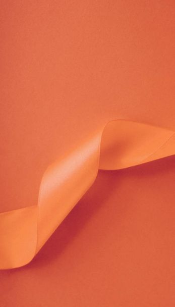 Abstract curly silk ribbon on orange background, exclusive luxur - Photo, Image