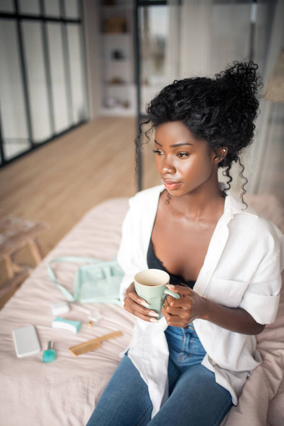 Woman wearing black bra drinking coffee and enjoying the moment - Foto, afbeelding