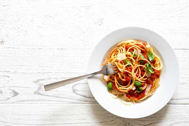Спагетті з виделкою, томатним соусом, свіжим базилем і сиром. Ізола - Фото, зображення