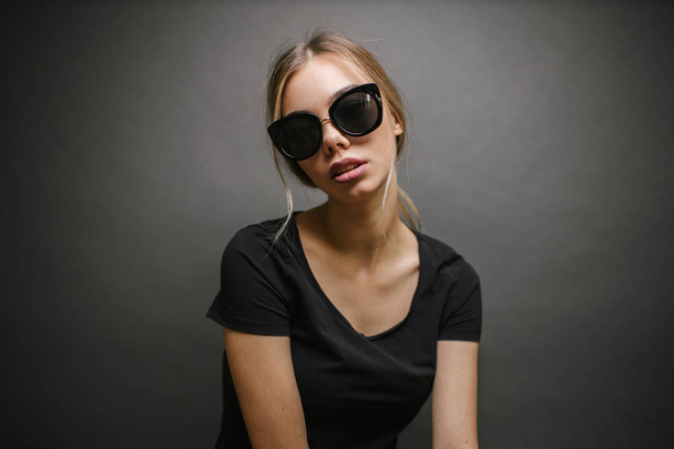 Fashion portrait of a sexy blonde woman with a make up wearing black clothes - Fotó, kép