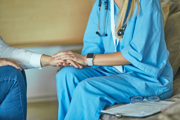 Hand of doctor reassuring her female patient - Foto, Imagen
