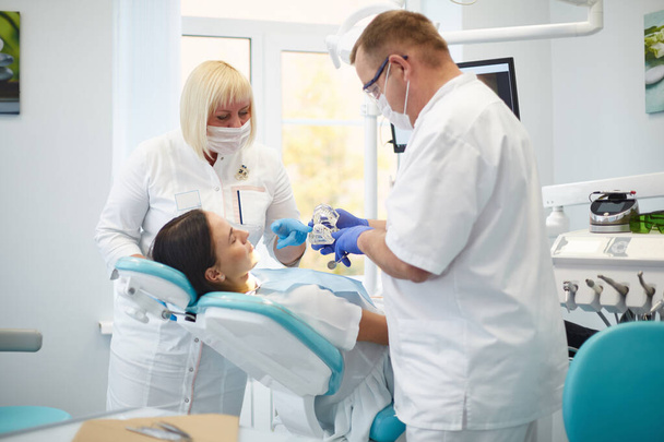 Zahnarzt behandelt Zähne einer schönen jungen Patientin. Das Mädchen an der Rezeption beim Zahnarzt. Zahnarzt behandelt Zahn - Foto, Bild