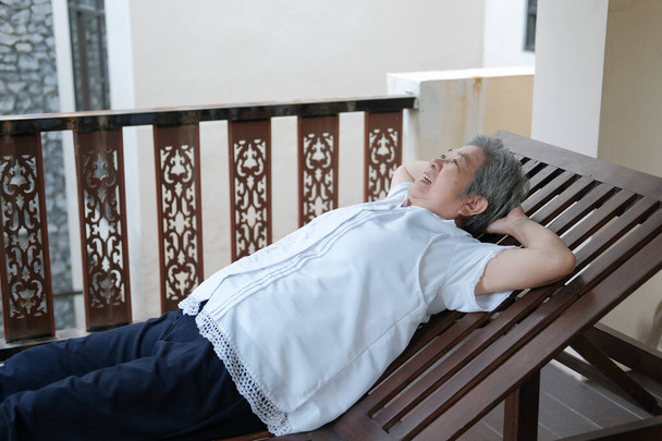 літня літня старша жінка відпочиває на терасі балкона
 - Фото, зображення